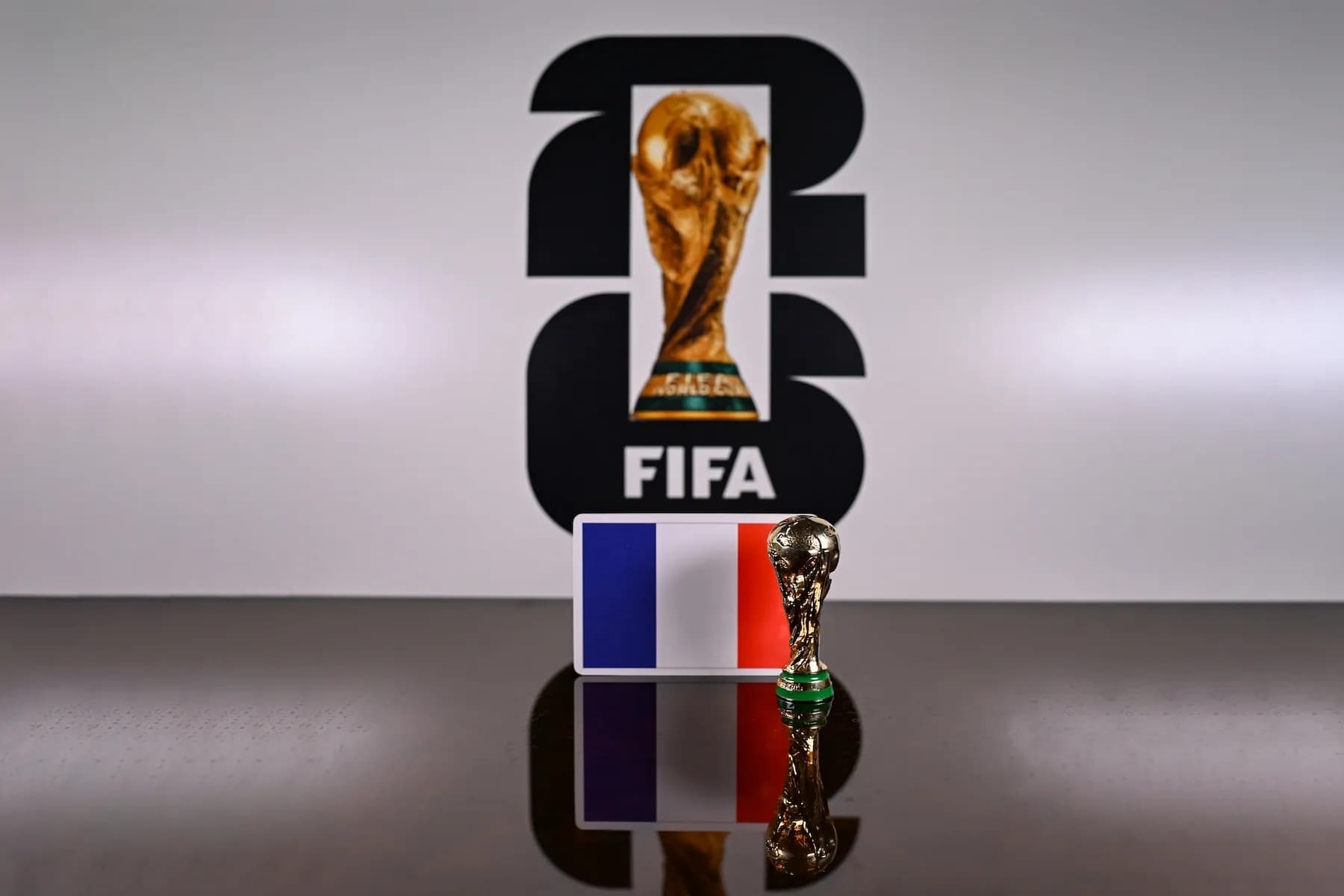 French flag displayed beside a FIFA World Cup trophy, representing AI predictions that France will win the 2026 FIFA World Cup.