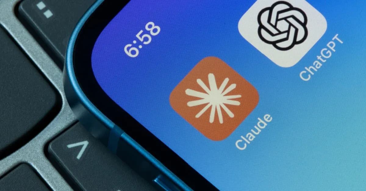 Close-up of a smartphone screen showing the ChatGPT and Claude app icons, with part of a laptop keyboard in the background.