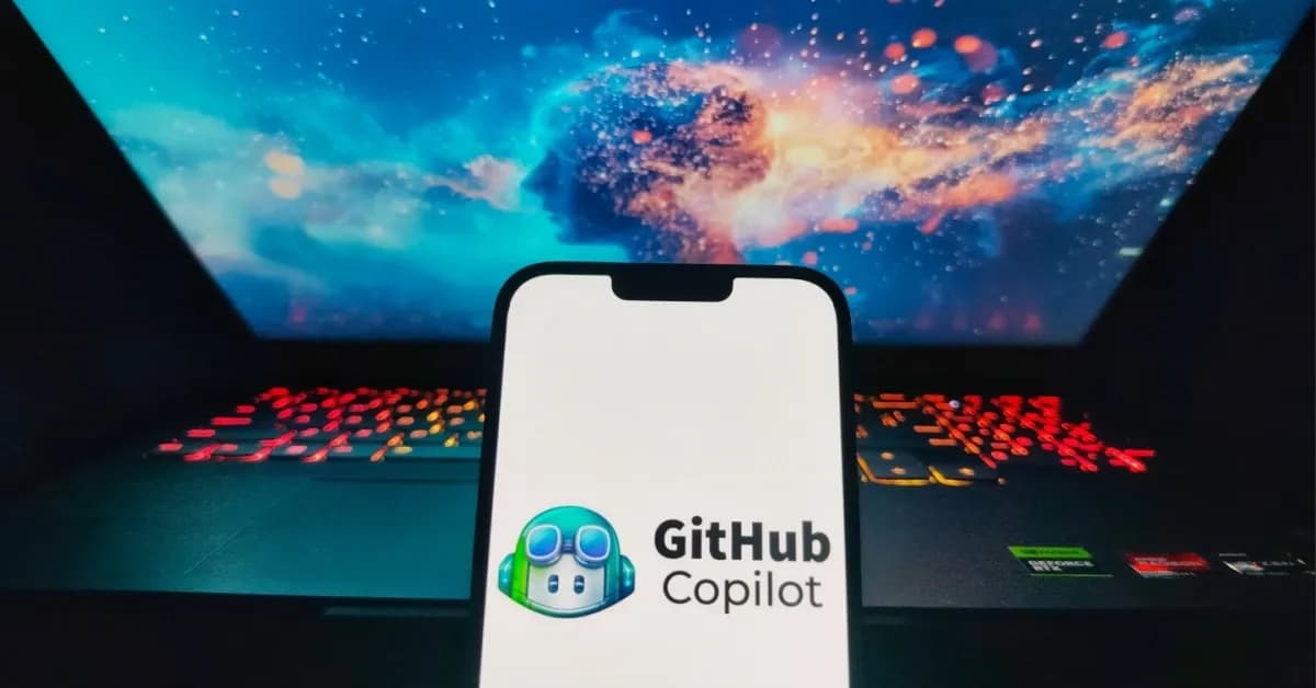 GitHub Copilot displayed on a smartphone with a laptop in the background