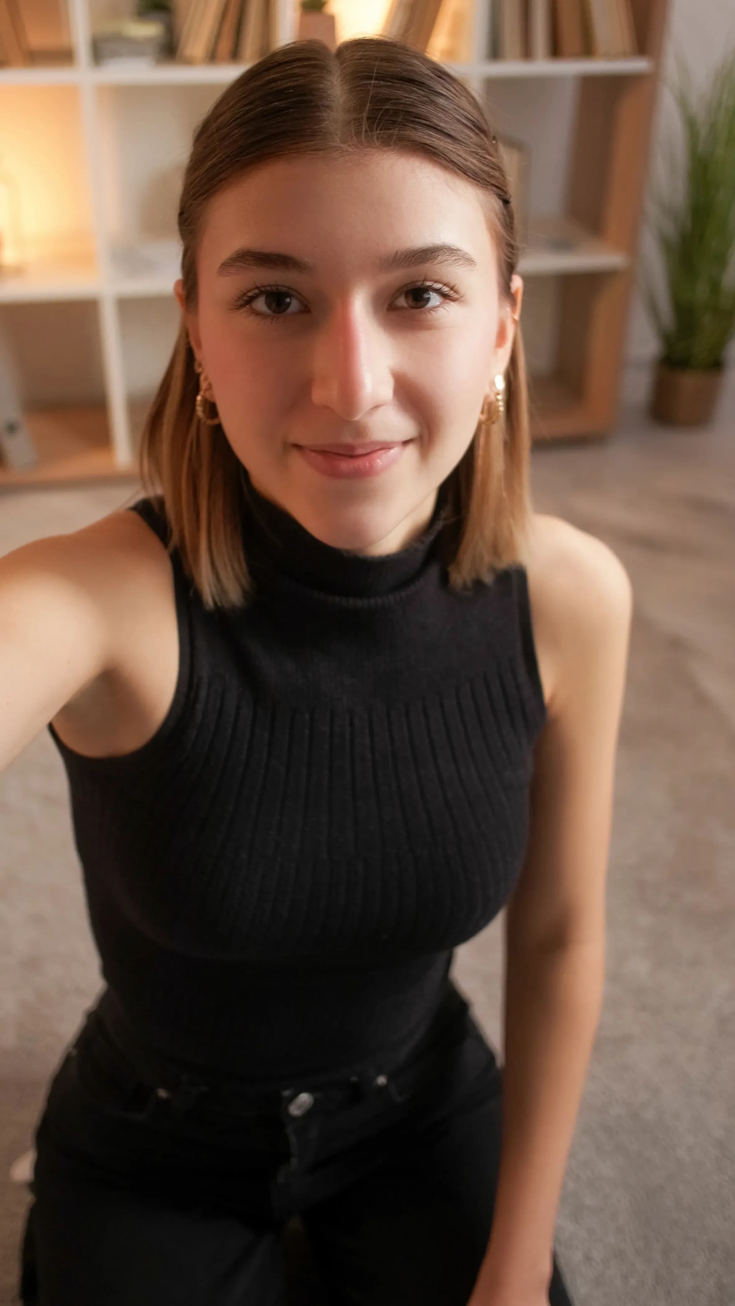 Indoor selfie of a young woman wearing a black sleeveless top, ideal for creating GTA-inspired AI portraits.